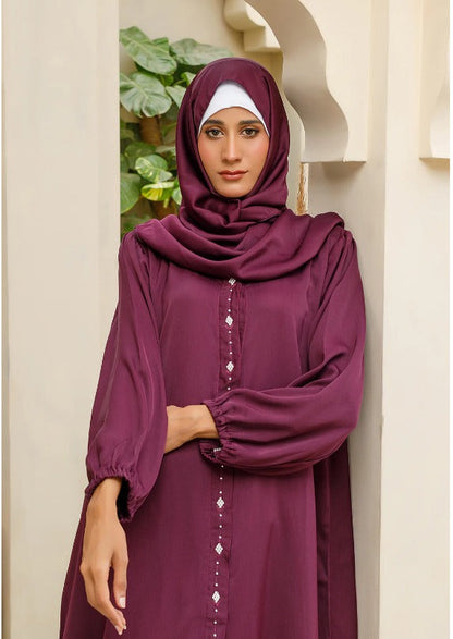 Elegant embellishment detail on maroon abaya front panel